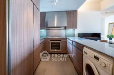 Modern kitchen with sleek wooden cabinets and built-in appliances.