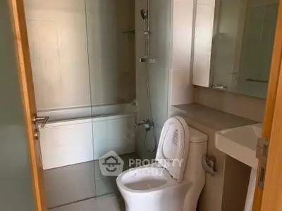Modern bathroom with glass shower and sleek fixtures in a contemporary home.