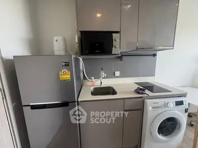 Compact modern kitchen with appliances including fridge, microwave, and washing machine.