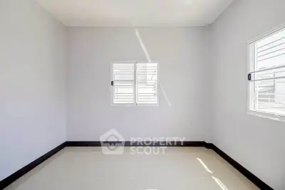 Bright empty room with two windows and tiled floor, perfect for customization.