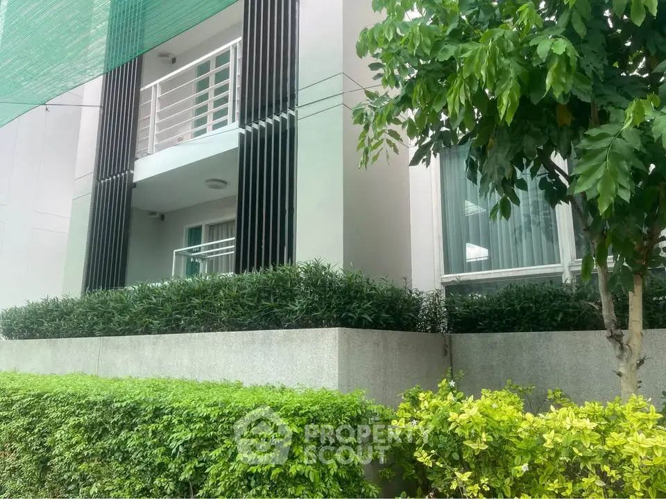Modern building exterior with lush greenery and balcony