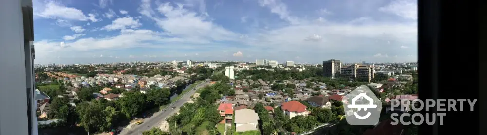 Panoramic cityscape view from high-rise building showcasing urban landscape and greenery.