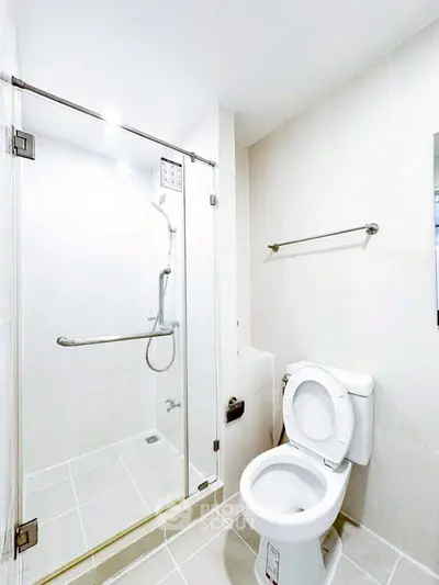 Modern bathroom with glass shower and toilet in bright white tones