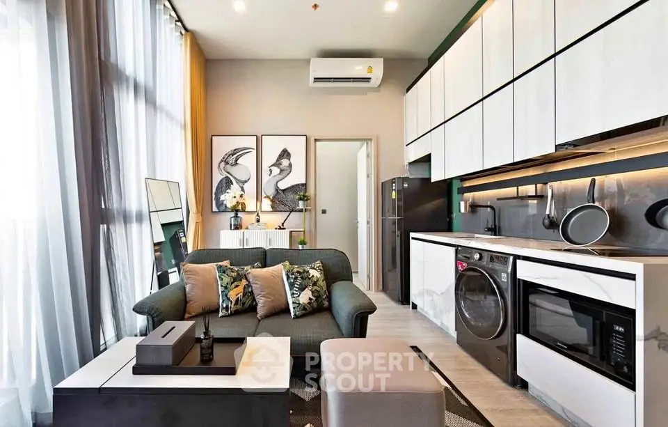 Modern living room with open kitchen, stylish decor, and natural light