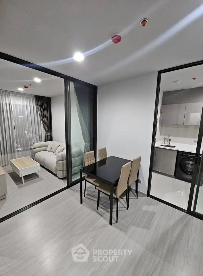 Modern apartment interior with open layout, featuring a cozy living room and sleek kitchen area.