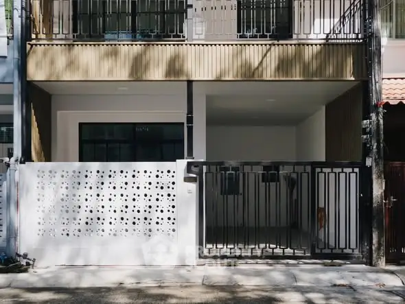 Modern townhouse exterior with gated entrance and stylish facade.
