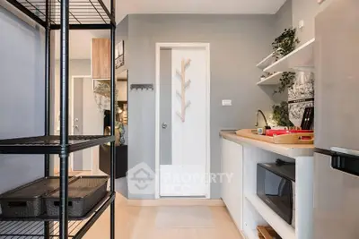 Modern kitchen with sleek design, open shelving, and compact appliances in a stylish apartment.