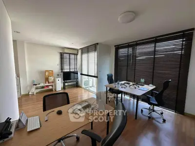 Modern study room with wooden flooring and large windows
