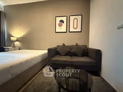 Modern bedroom with stylish decor, featuring a cozy sofa and elegant artwork, perfect for relaxation.