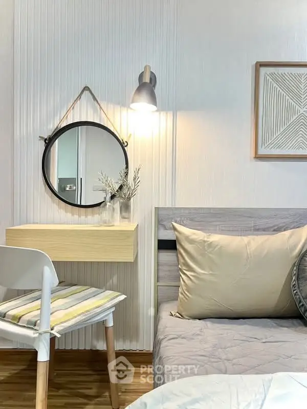 Cozy bedroom with modern decor, featuring a stylish wall-mounted mirror and elegant lighting.