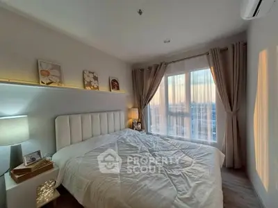 Cozy bedroom with large window and elegant decor, offering a serene ambiance and natural light.