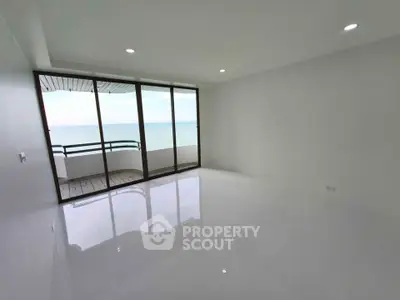 Spacious living room with ocean view and large balcony access.