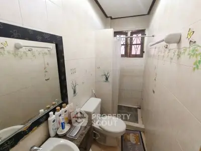 Cozy bathroom with shower, toilet, and sink in a compact layout.