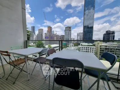 Spacious balcony with city skyline view, perfect for outdoor dining and relaxation.