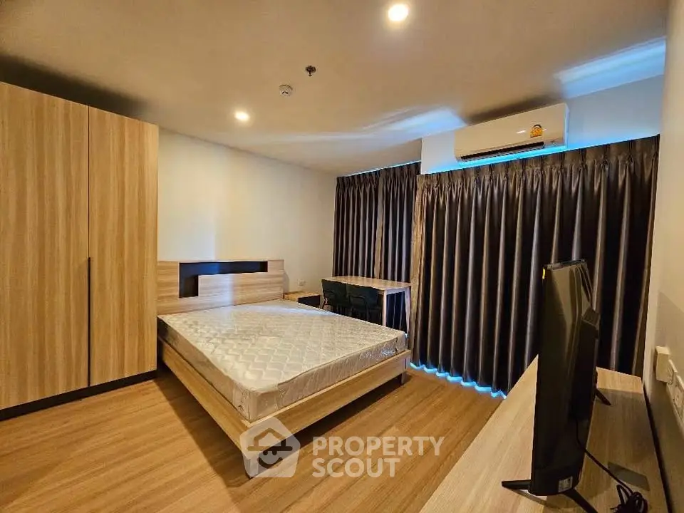 Spacious modern bedroom with wooden flooring and stylish furniture