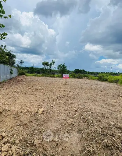 Expansive vacant land plot under a cloudy sky, ideal for development opportunities.