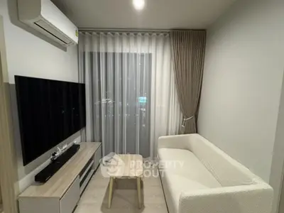 Modern living room with sleek furniture and large TV, perfect for cozy evenings.