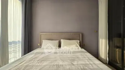 Modern bedroom with large windows and elegant decor, perfect for relaxation and comfort.