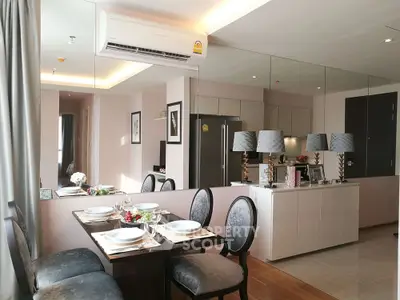 Modern dining area with elegant table setting and mirrored wall in stylish apartment
