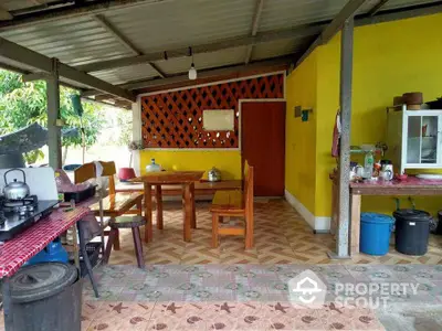 Charming rustic outdoor kitchen with vibrant yellow walls and wooden furniture