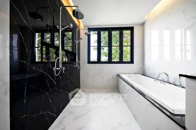 Luxurious modern bathroom with black marble shower and large bathtub