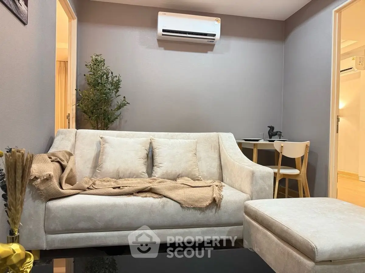 Cozy living room with modern sofa and air conditioning, perfect for relaxation.