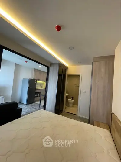 Modern studio apartment with open layout, featuring a cozy bedroom and sleek kitchen area.