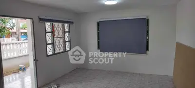 Spacious room with tiled floor and large windows, ideal for versatile living space.