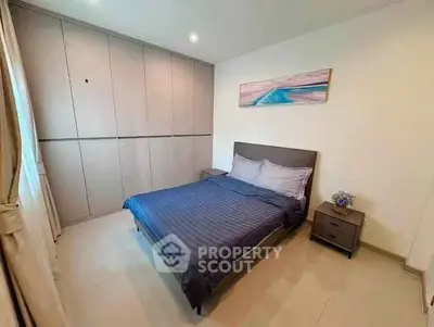 Modern bedroom with sleek design and ample storage in a stylish apartment.