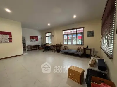 Spacious living room with large windows and modern decor, perfect for family gatherings.