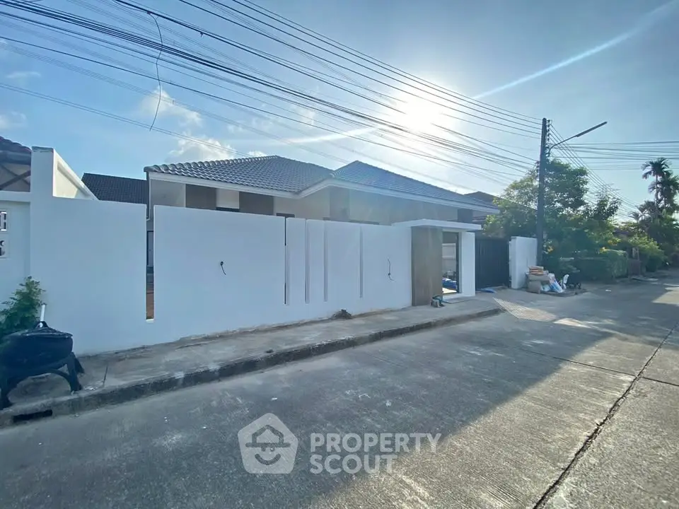 Charming suburban house with modern design and spacious driveway under a clear blue sky.