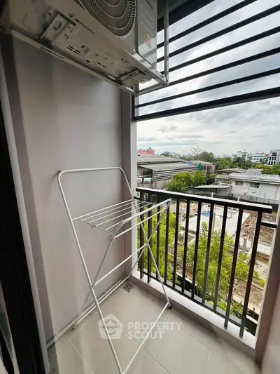Compact balcony with city view and drying rack, perfect for urban living.