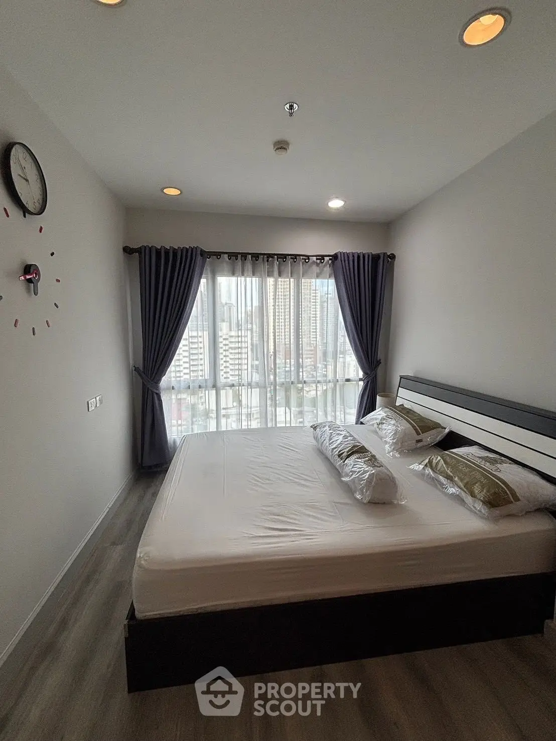 Modern bedroom with city view, stylish decor, and natural light