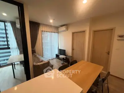 Modern living room with dining area and large windows in a stylish apartment.
