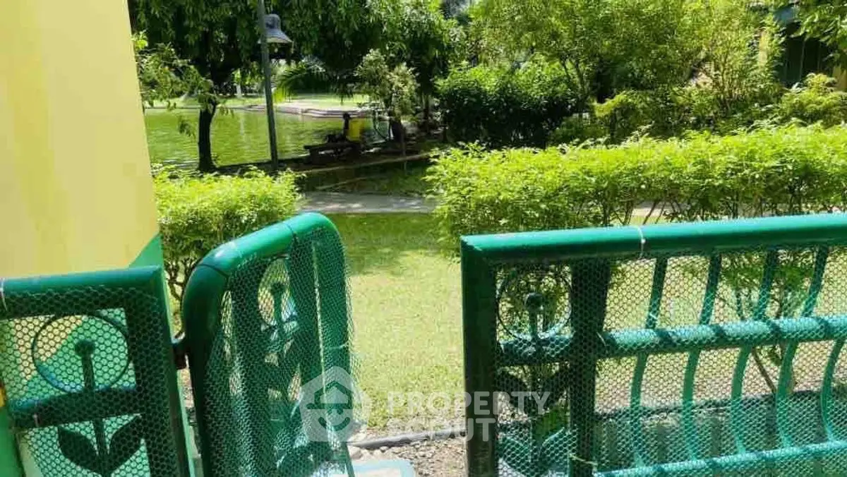 Charming garden view from a green-fenced patio, perfect for relaxation and outdoor enjoyment.
