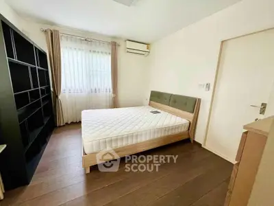 Spacious bedroom with modern furnishings and natural light, featuring a comfortable bed and ample storage.