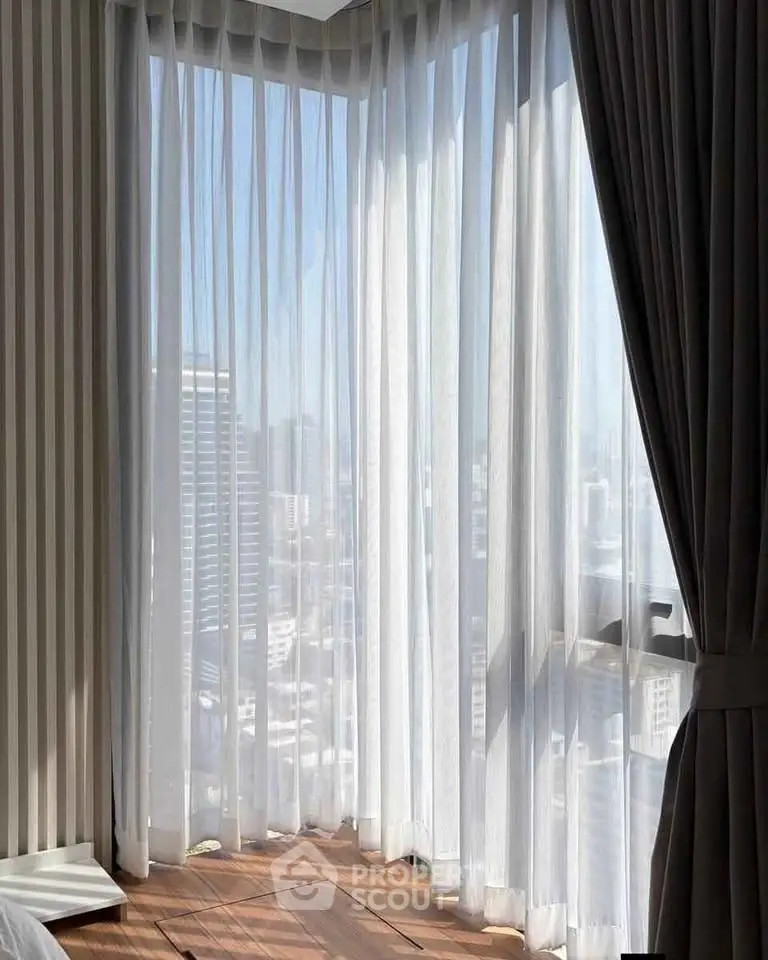 Elegant corner unit with floor-to-ceiling windows offering a stunning city view, perfect for urban living.