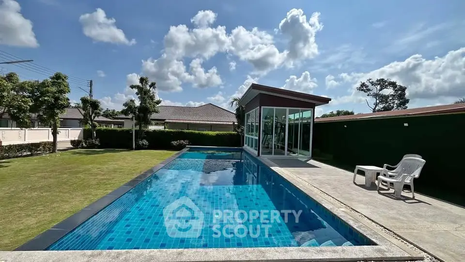 Luxurious private pool with modern glass-walled gym and lush garden setting.