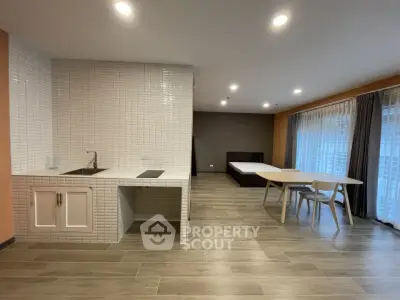 Spacious open-plan living area with modern kitchen and large windows.
