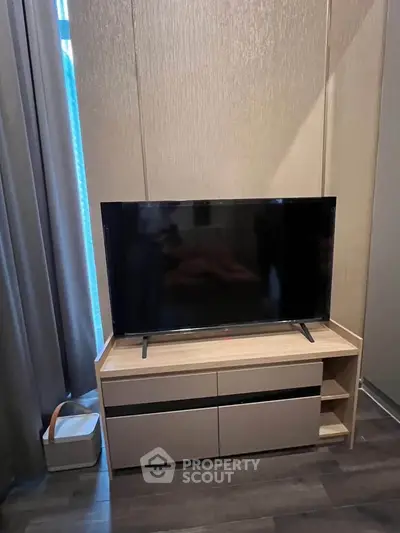 Modern living room with sleek TV stand and flat-screen TV, perfect for entertainment.