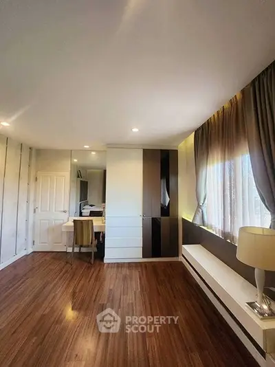 Spacious modern bedroom with wooden flooring and elegant decor