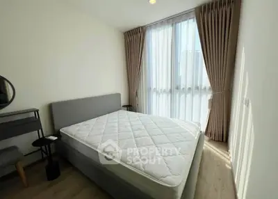 Bright and airy bedroom with large windows and modern furnishings in a stylish apartment.