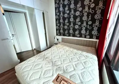 Modern bedroom with stylish wallpaper and large window offering natural light.