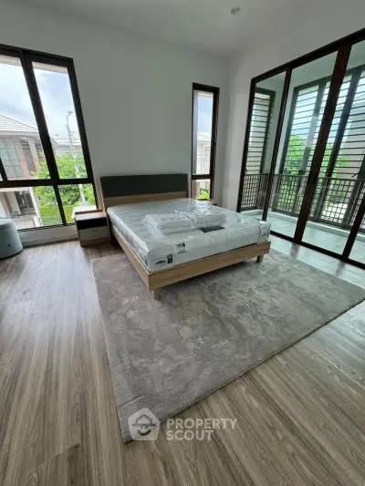 Spacious bedroom with large windows and balcony access in modern home