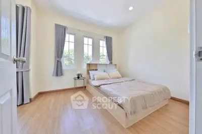 Bright and cozy bedroom with large windows and wooden flooring