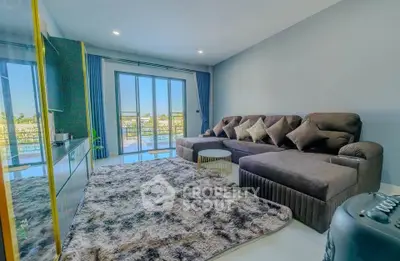 Spacious modern living room with plush sofa and large windows offering scenic views.