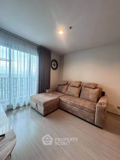 Spacious living room with cozy sectional sofa and large window offering natural light.