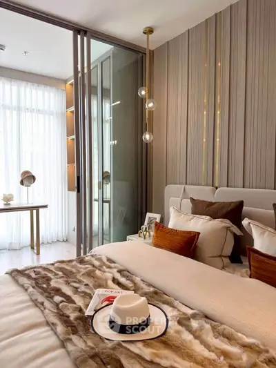 Luxurious bedroom with elegant decor and natural light, featuring a cozy bed and stylish pendant lighting.