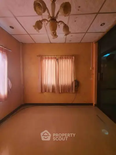 Spacious empty room with warm lighting and large windows, ideal for customization.