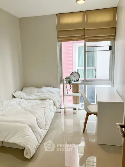 Modern minimalist bedroom with sleek desk and cozy bed, perfect for urban living.